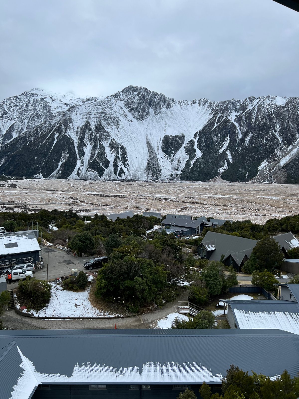 Snowy range over village rooftops