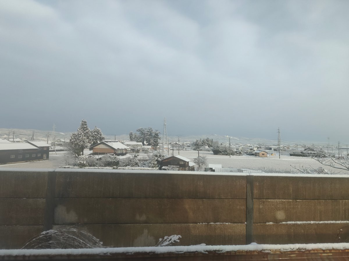 Snowy valley fields and a concrete barrier wall
