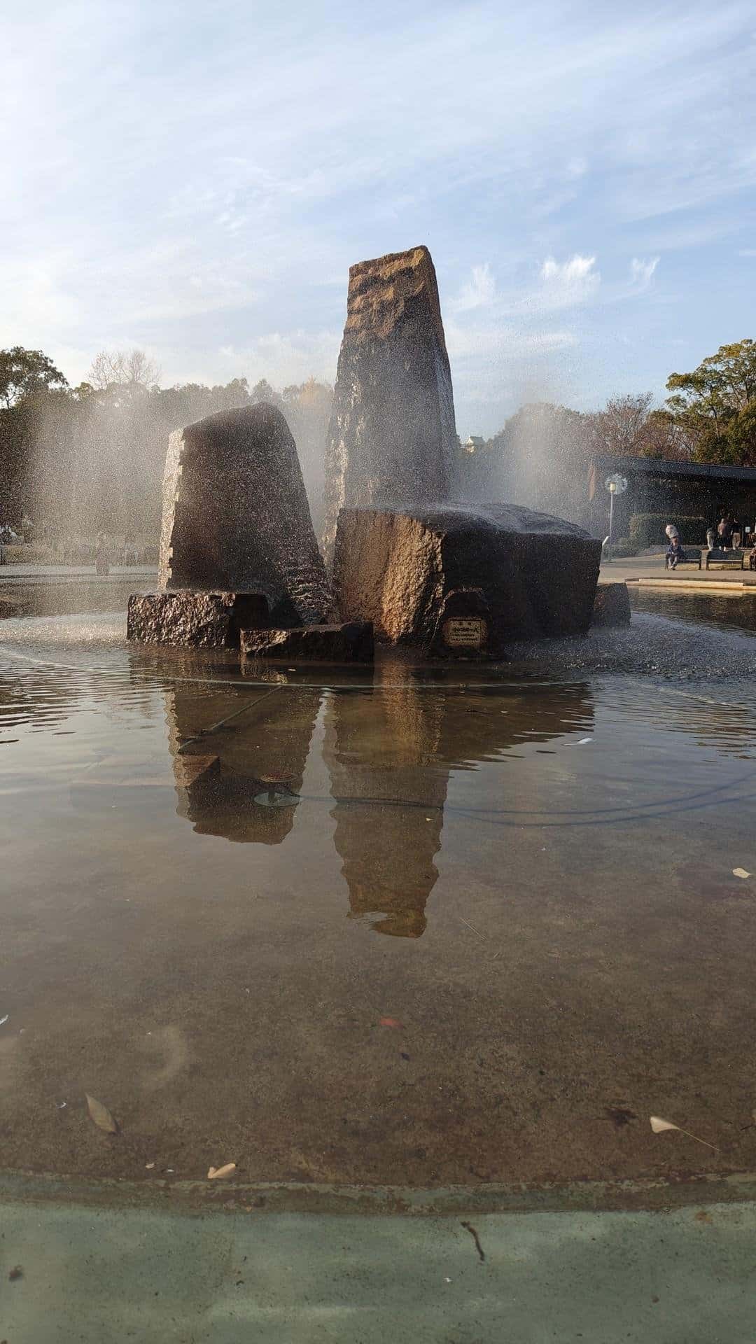 Stone fountain with mist and reflection