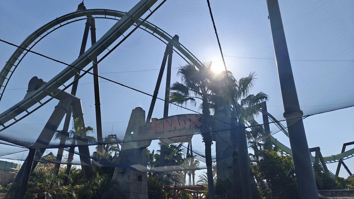 Sunlit theme park roller coaster entrance