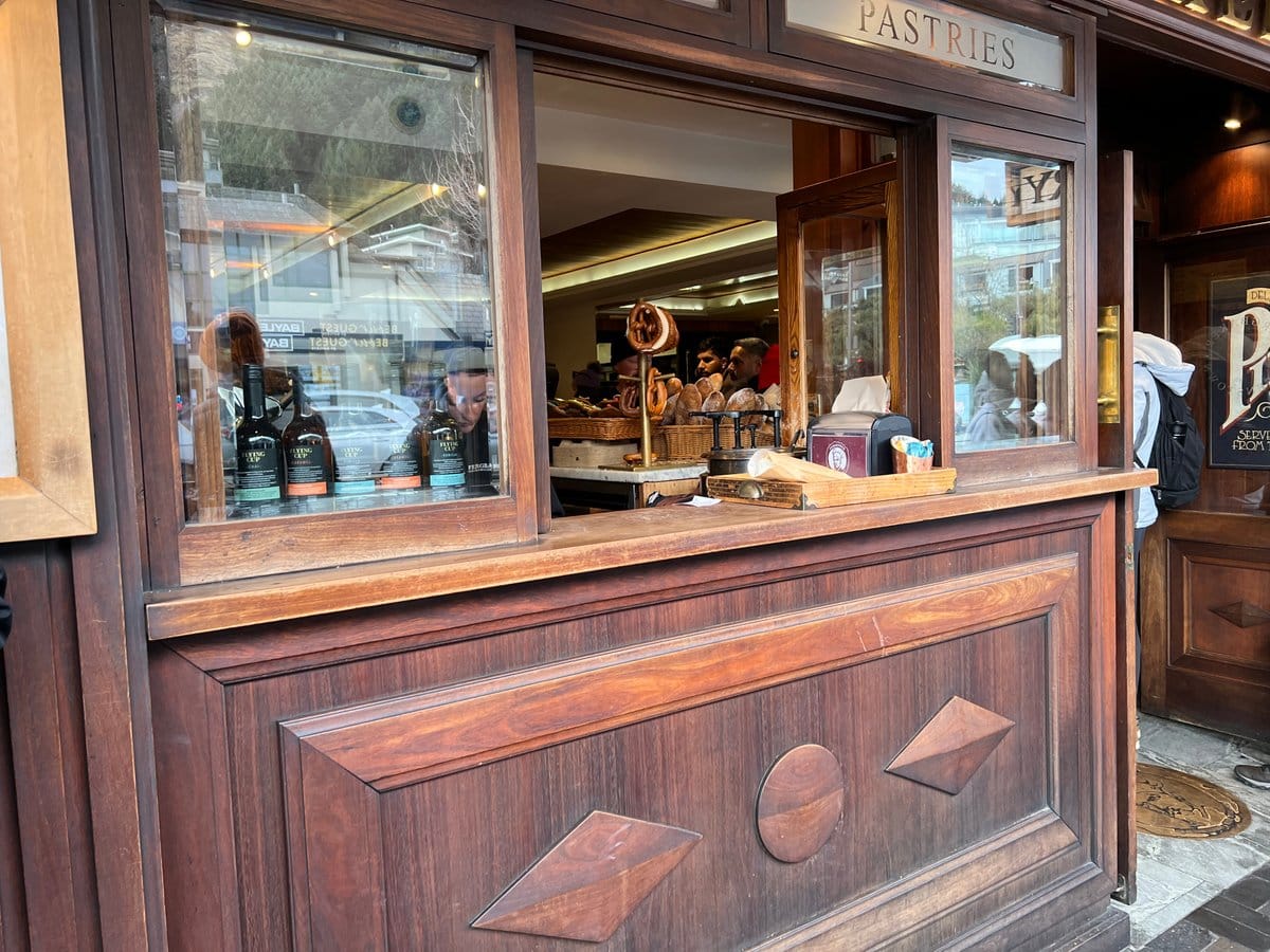 The bakery's 'PASTRIES' window with people peering in