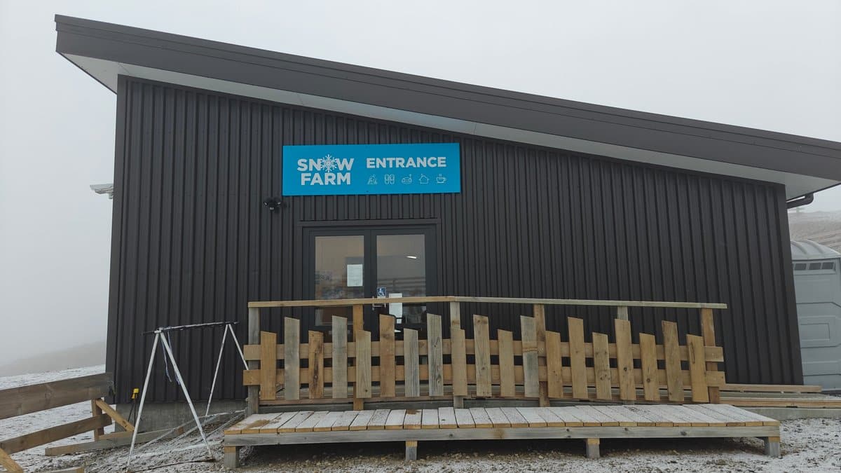 The base building's timber-ramped entrance under the blue