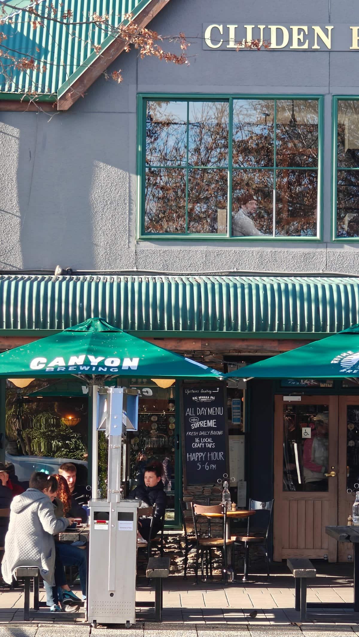 The cafe's green-striped awning and street-side patio with