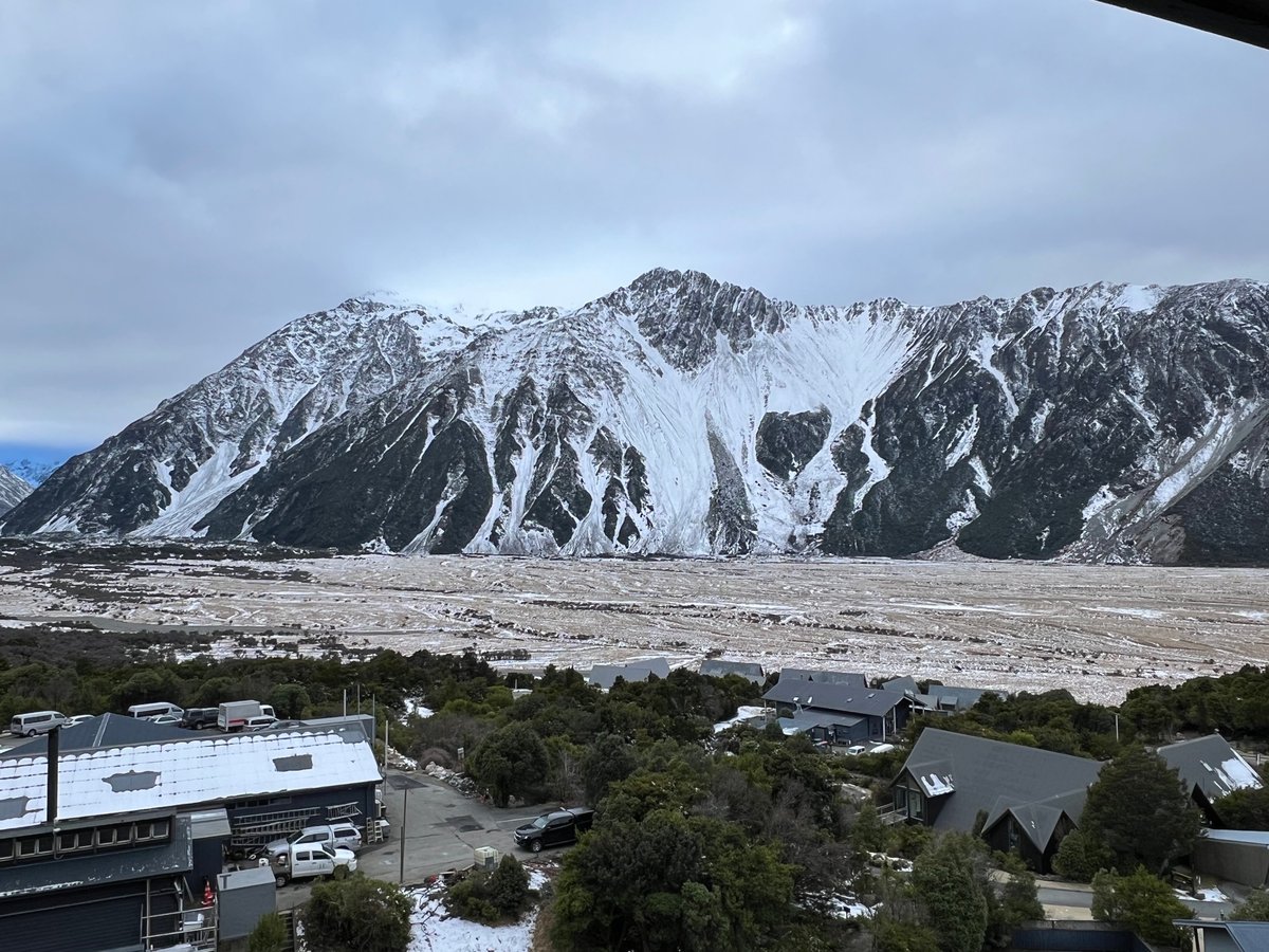 The snow-covered mountain wall rising above the village