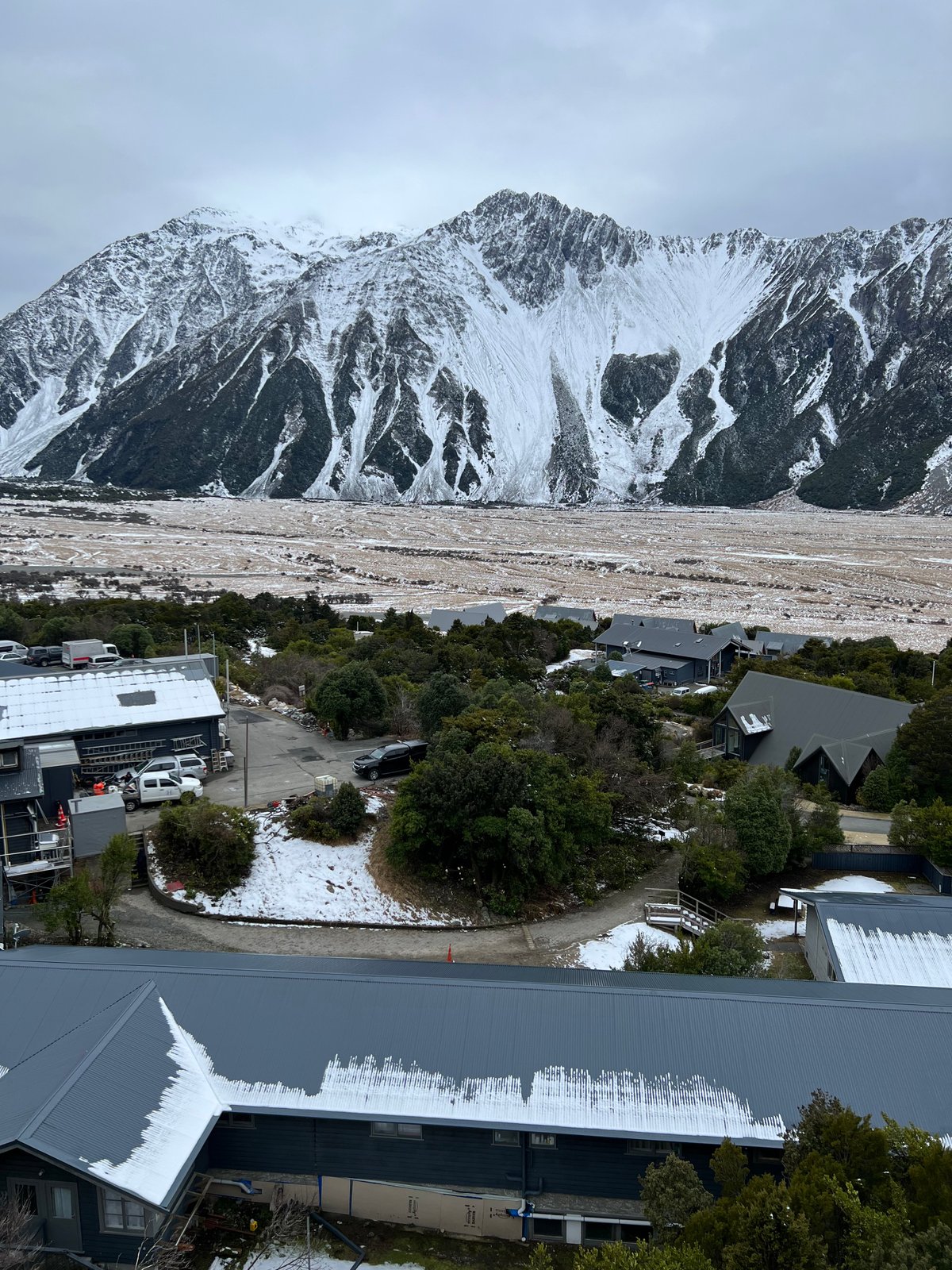 The snowy range over the village rooftops (vertical).
