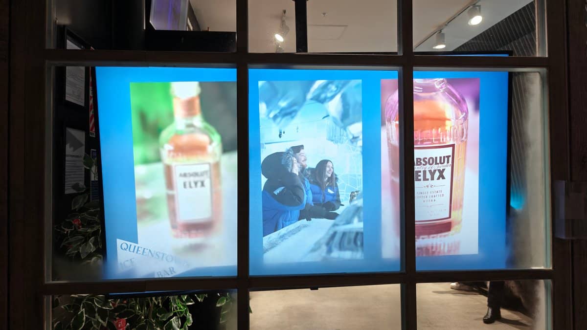 Three illuminated advertising light-boxes at the entrance displaying