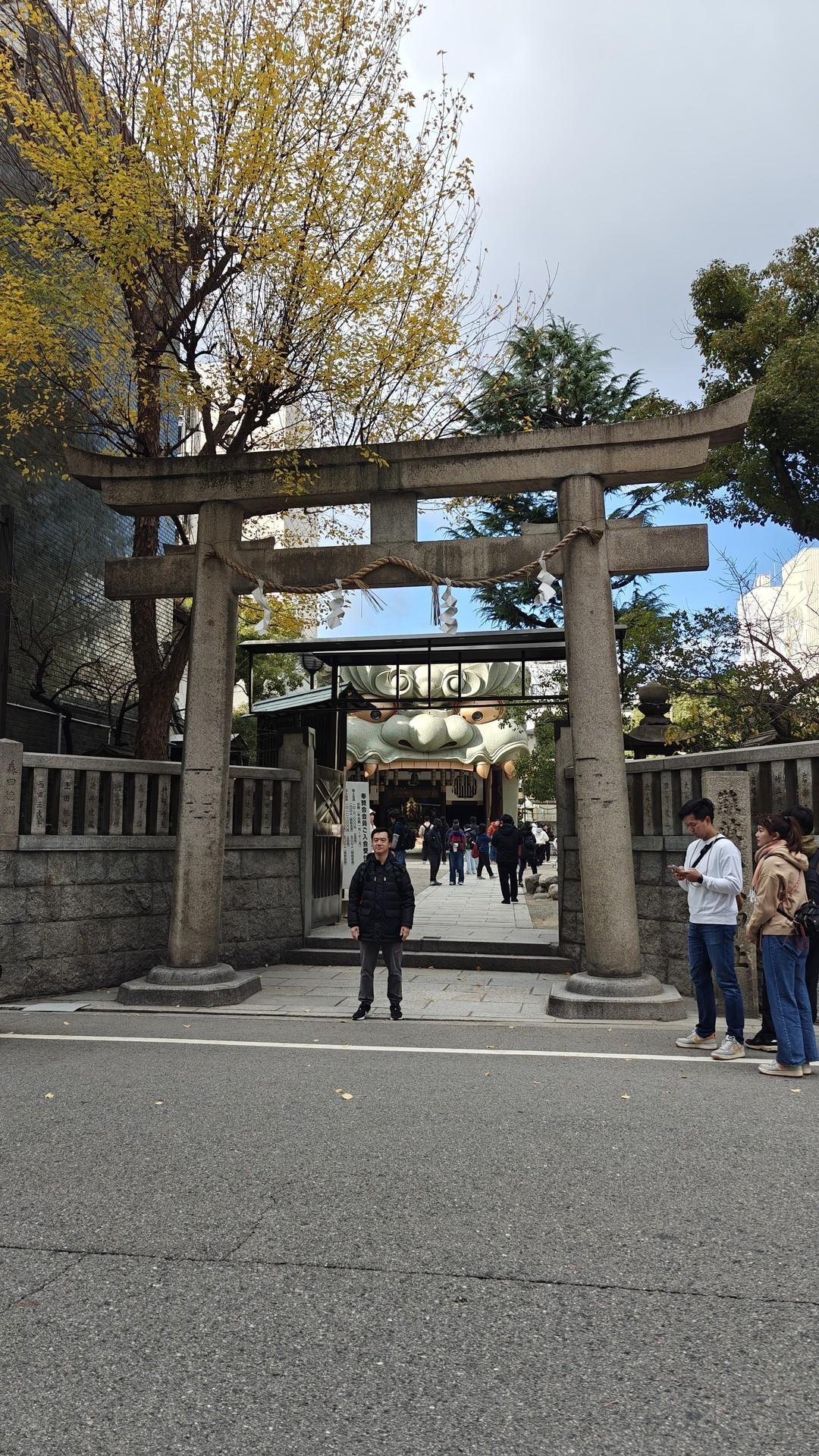 Torii gate with people and trees