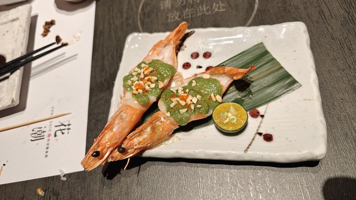 Two large prawns with green herb/basil sauce, peanuts,