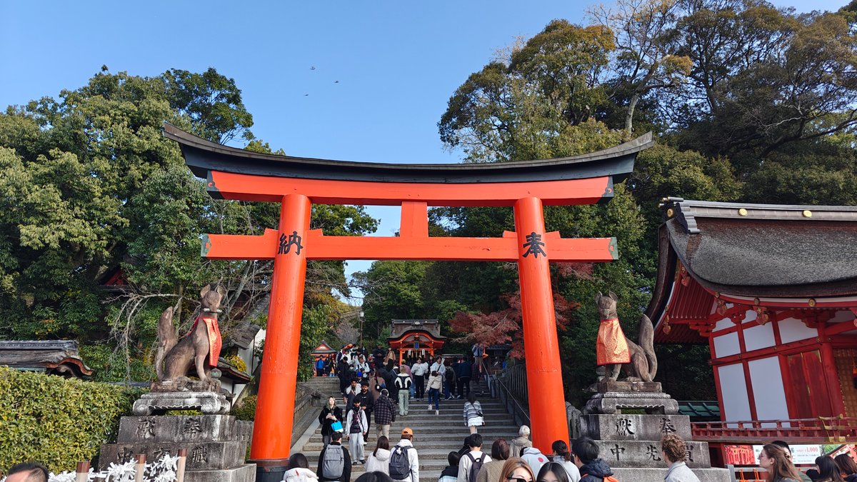Vermilion torii against a rocky, wooded hillside
