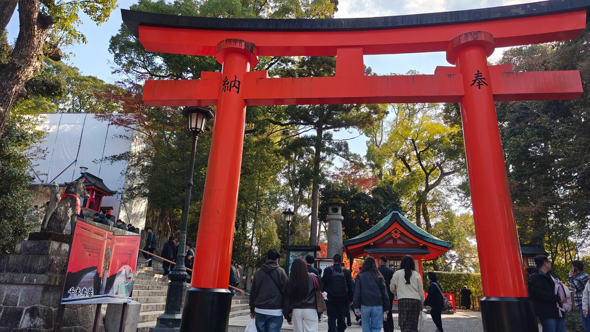 Vermilion torii over the walking path with visitors