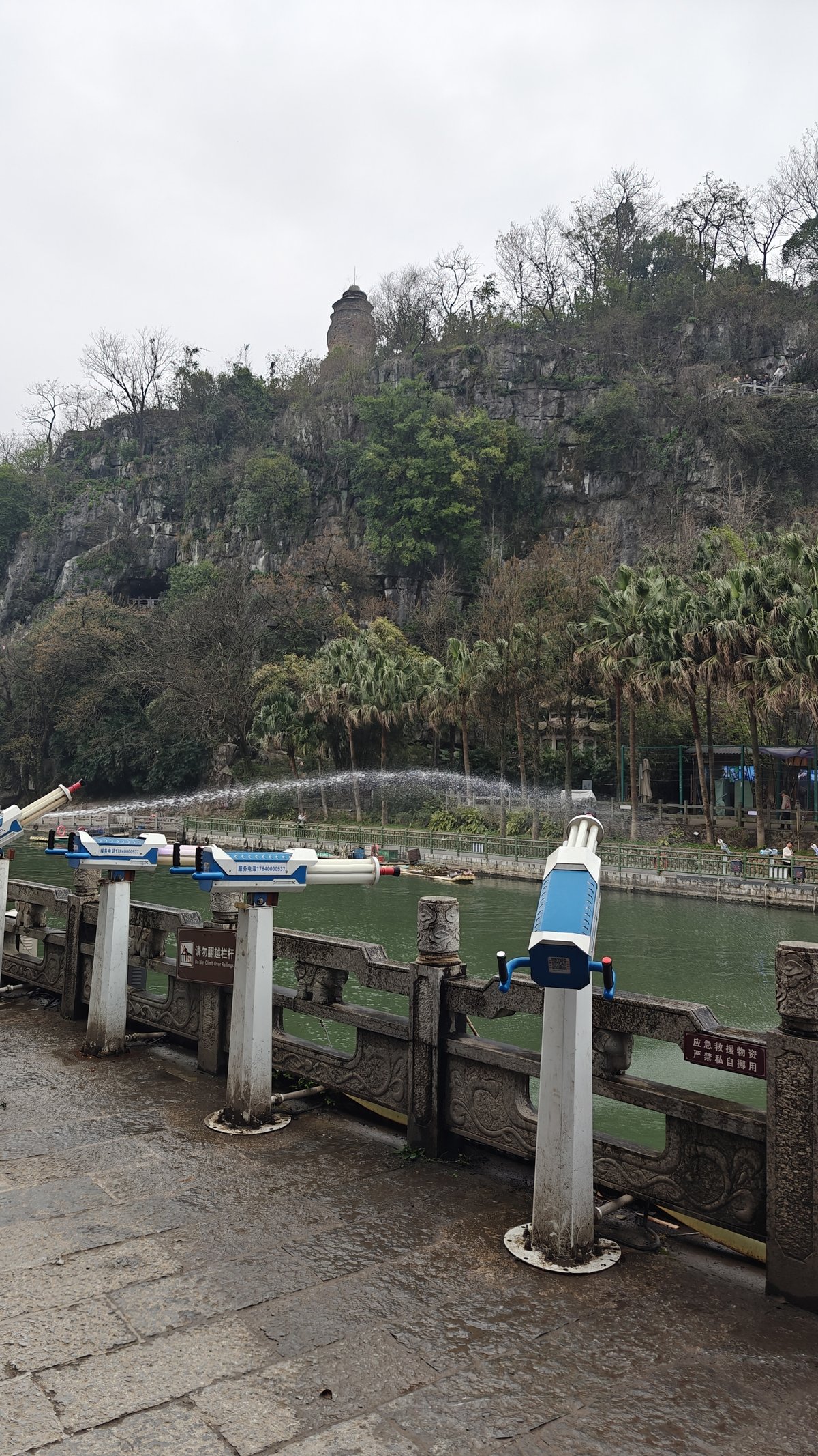 Viewpoint with coin-operated binoculars, river with fountain and