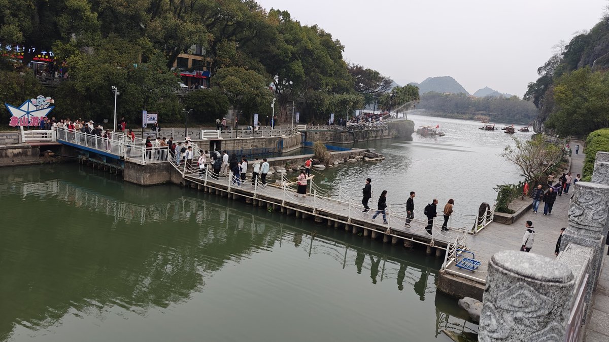 Waterfront view with pontoon bridge over green water,