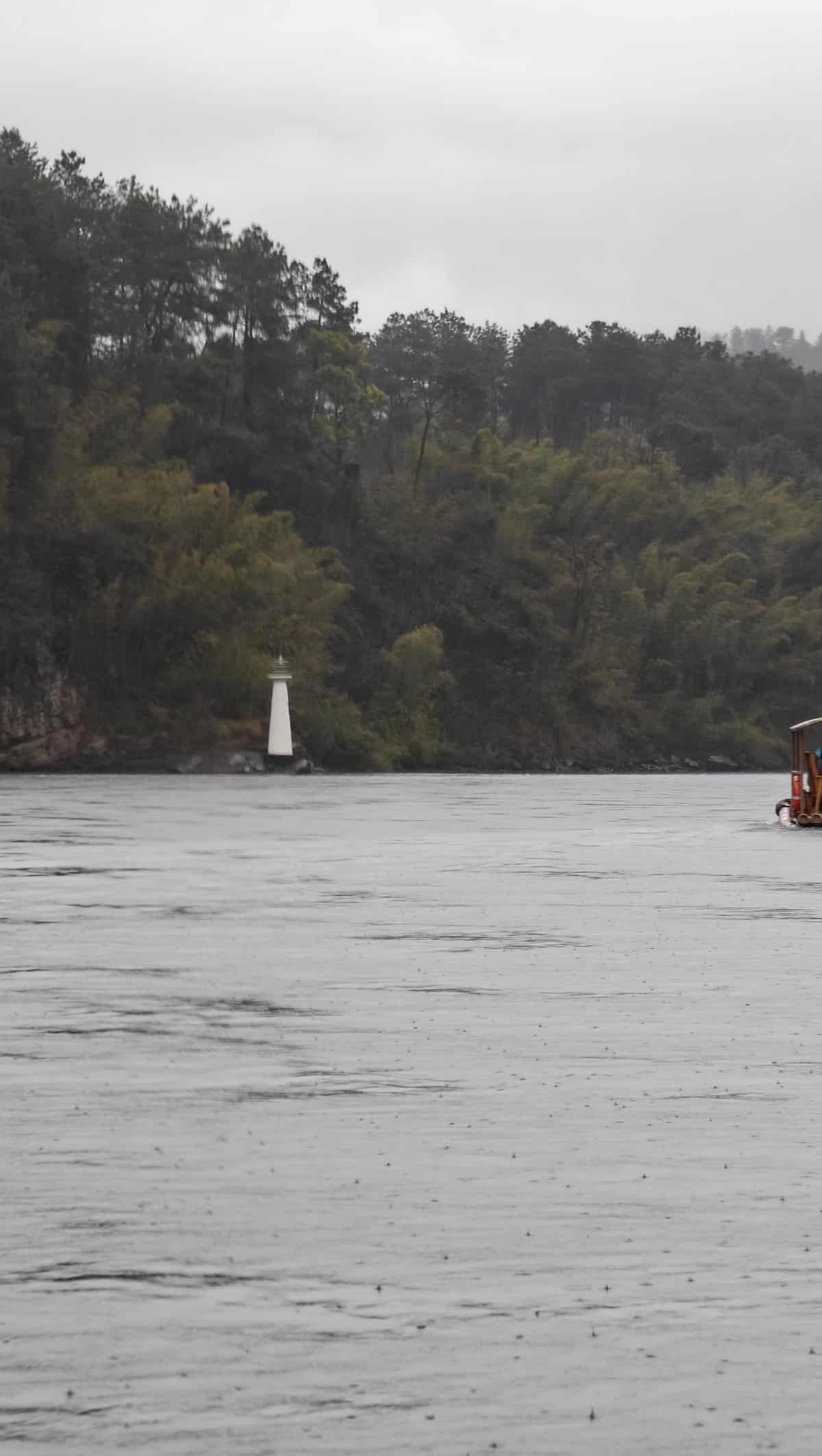 White navigation marker (small lighthouse) on riverbank with