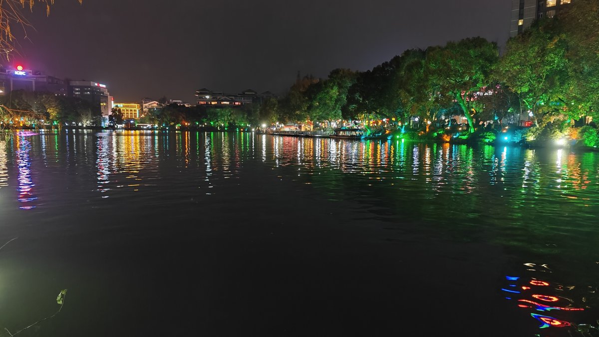 Wide night lake with city lights