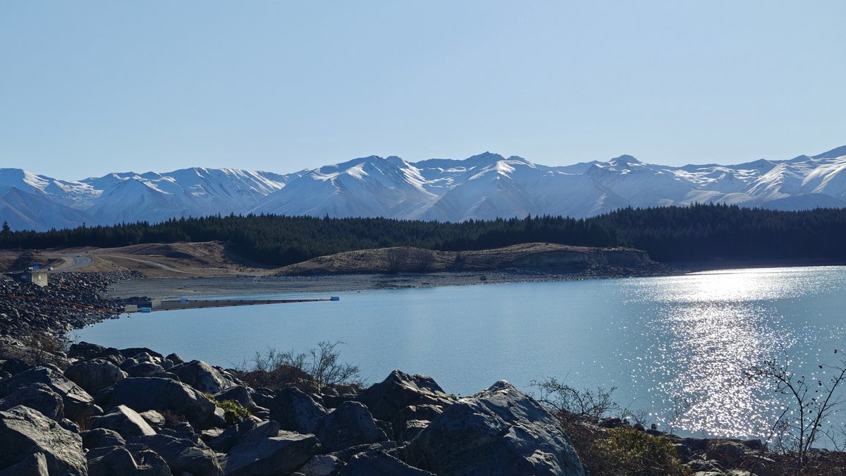 Wide view across Lake Pukaki with sun-glare on