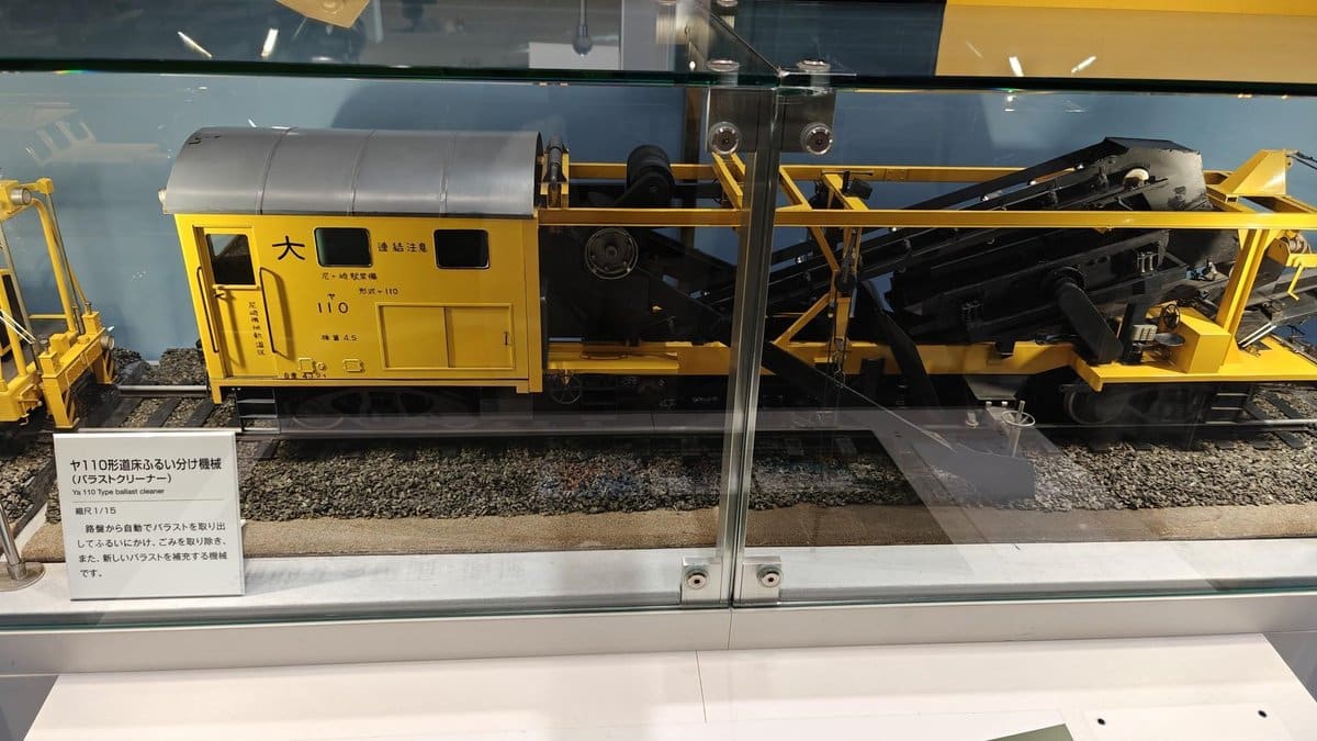 Yellow train model behind glass display