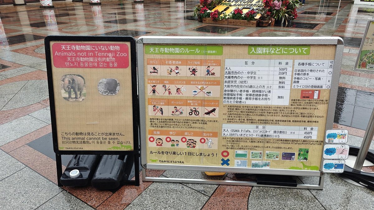 Zoo information signs on wet pavement