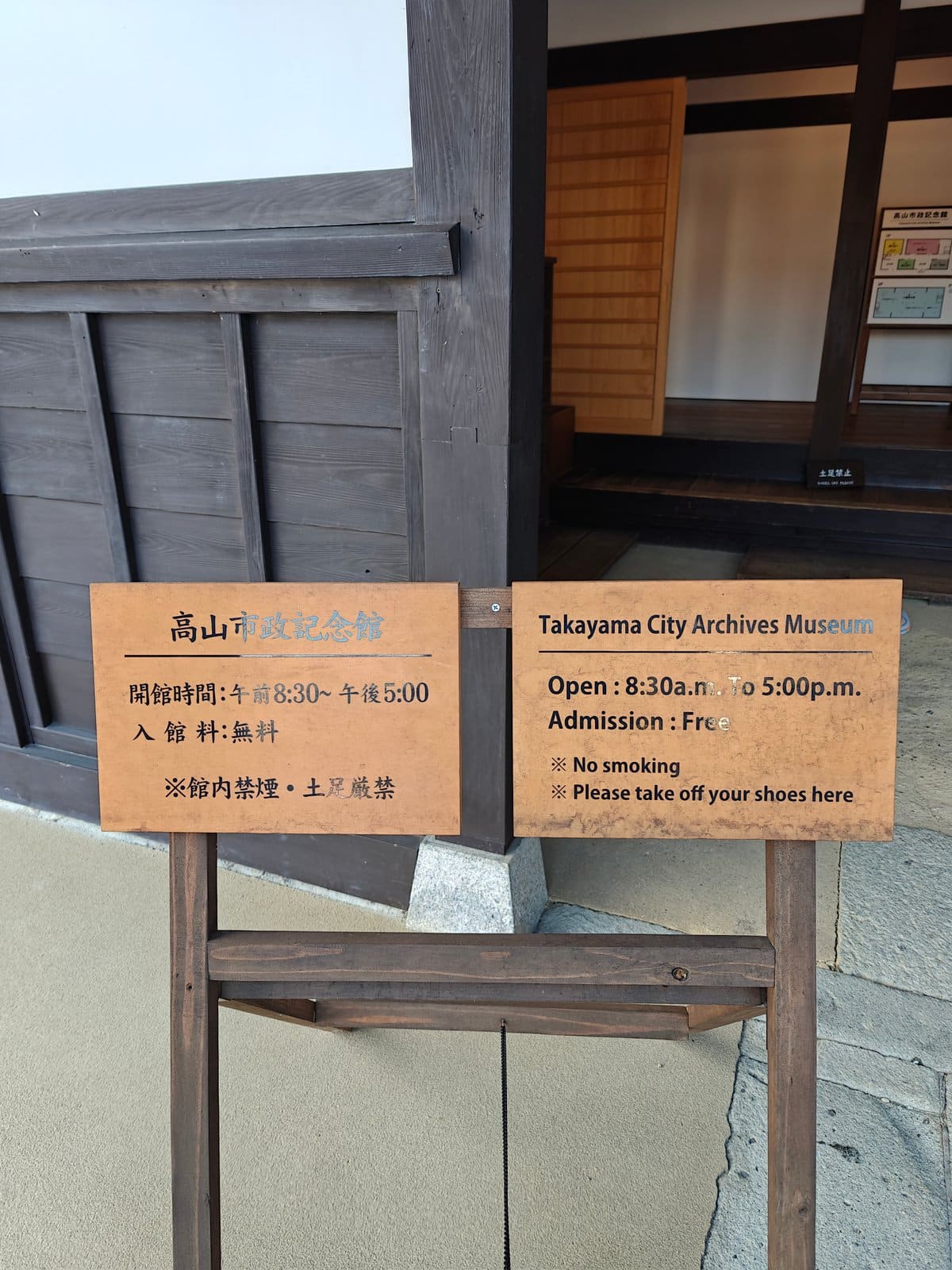 A-frame sandwich-board sign at the entrance. Japanese panel:
