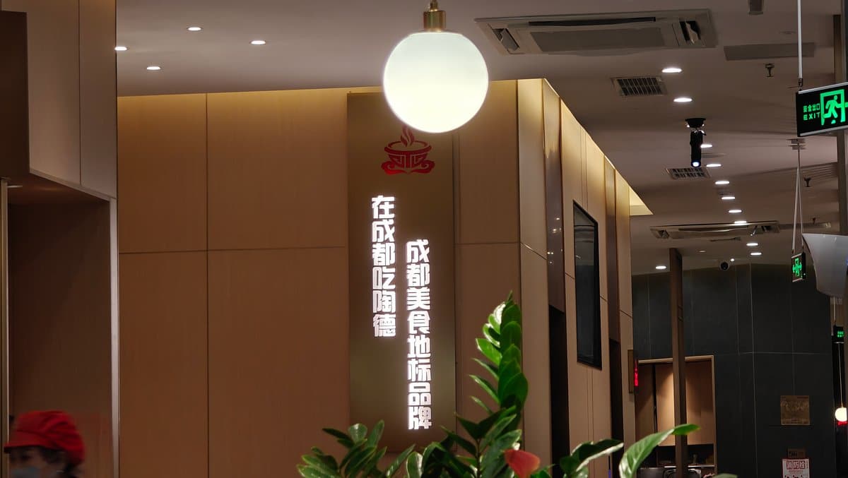 A glowing spherical pendant lamp beside a feature