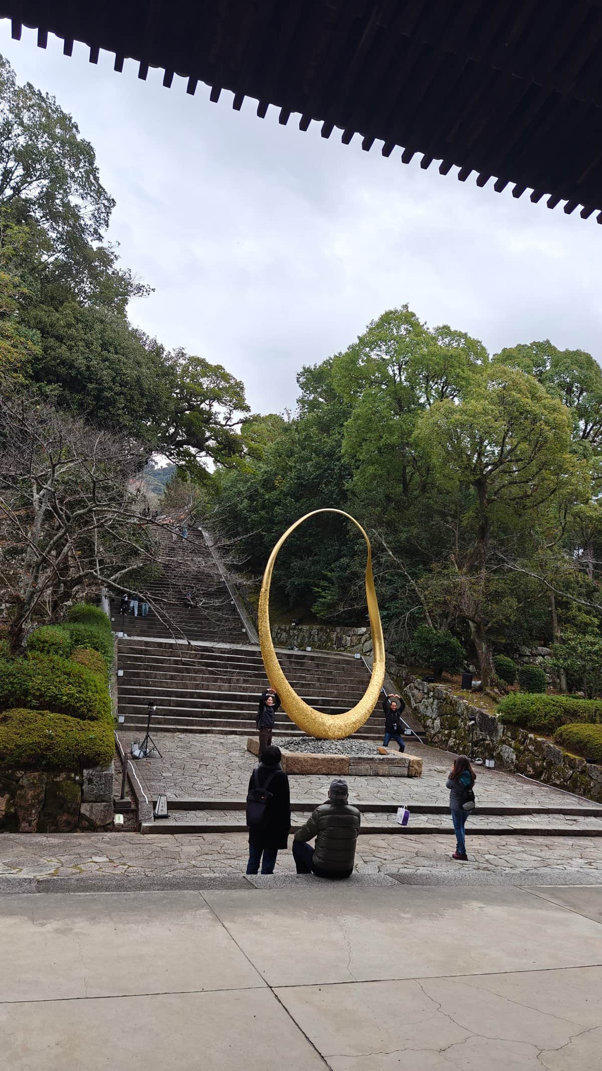 A large golden ring sculpture framed beneath the
