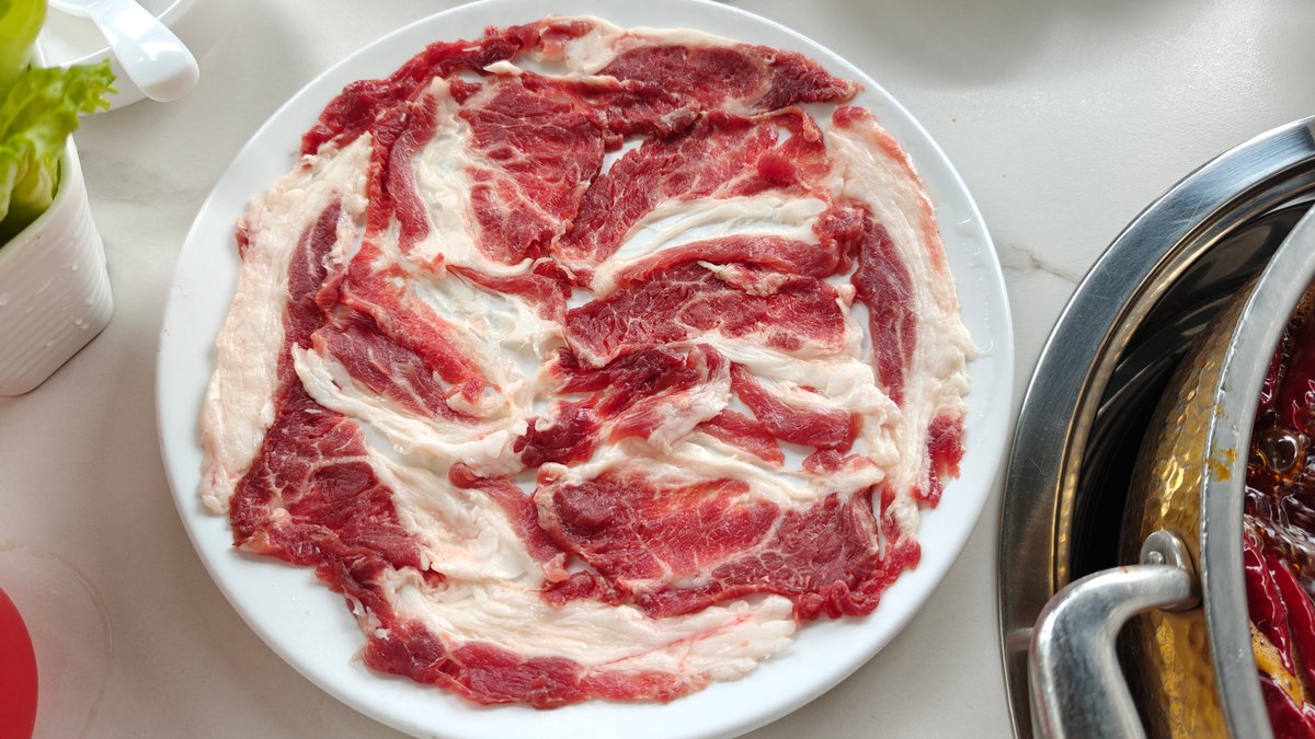 A plate of marbled beef/lamb belly slices beside