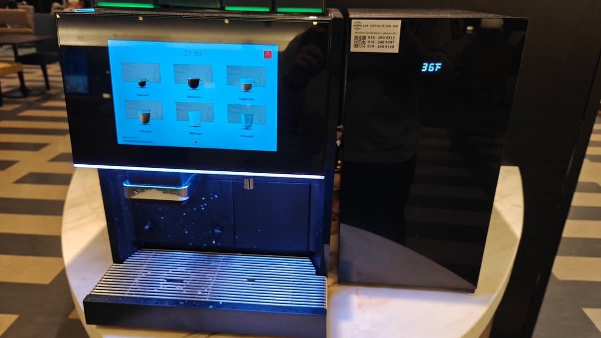 Automatic coffee machine touchscreen showing Espresso, Americano, Cappuccino,