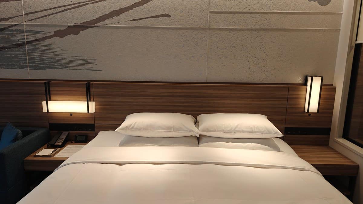 Bedroom with bed and modern mirror wall panel