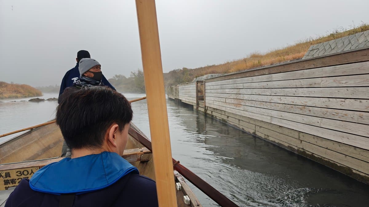 Boatman poling on misty river