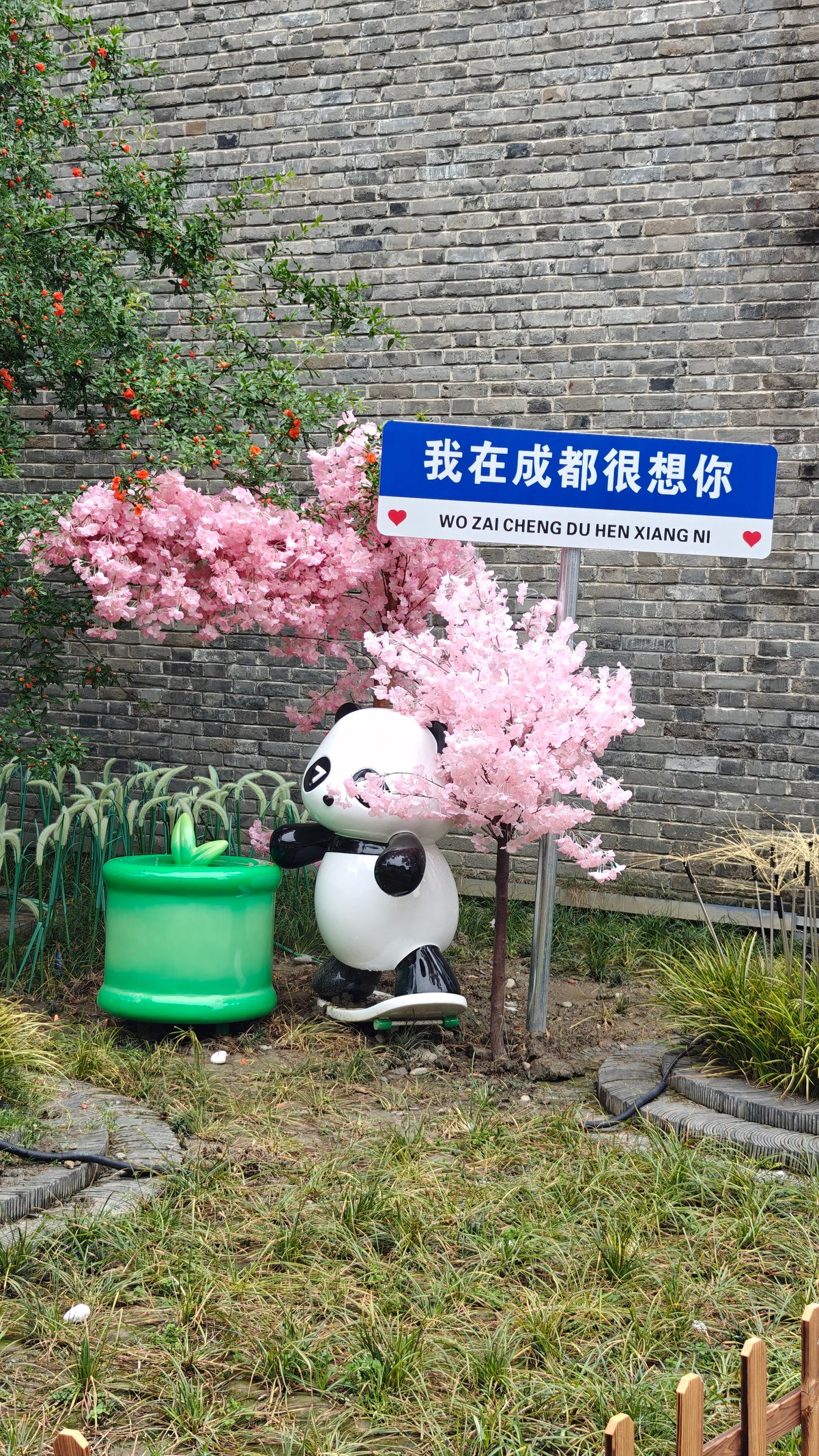Cherry-blossom tree with a reclining panda sculpture and
