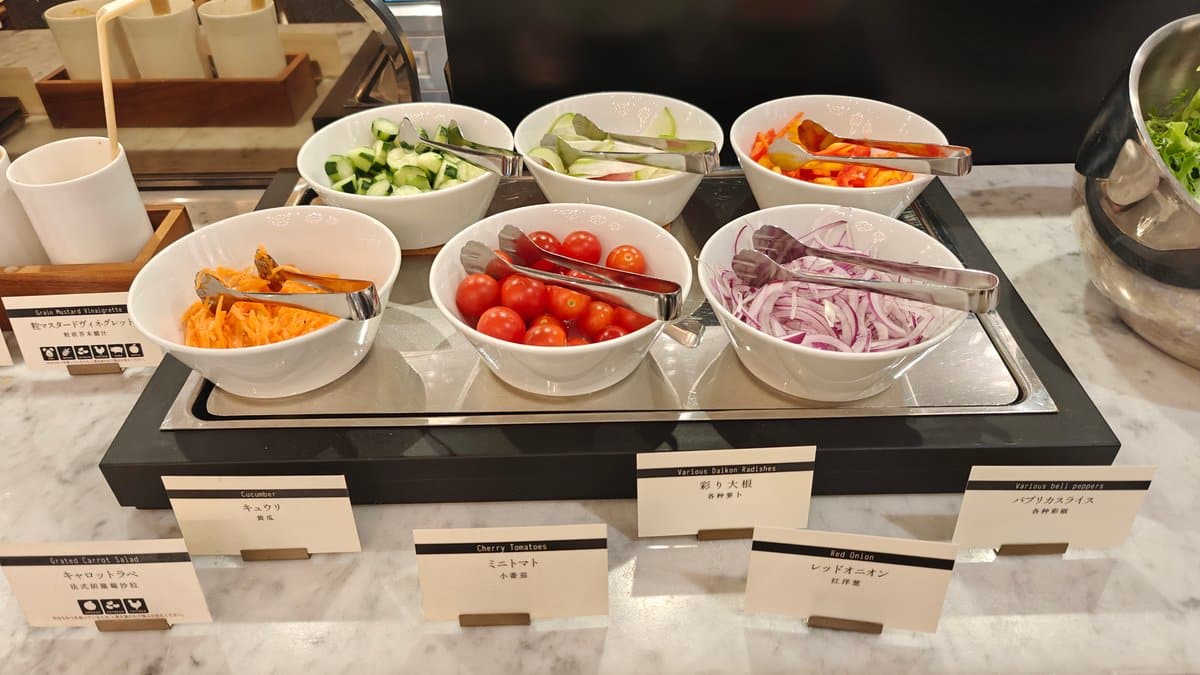 Cold buffet vegetables - tomatoes, onions and greens