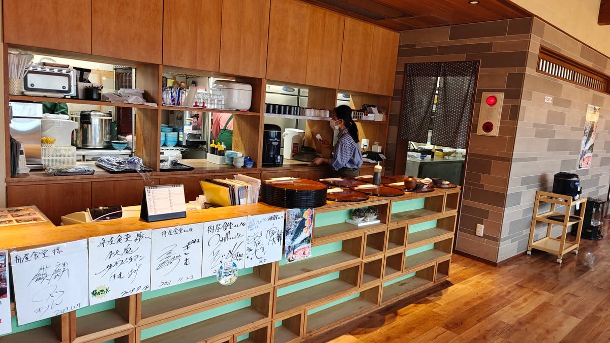 Counter with staff and a handwritten menu board