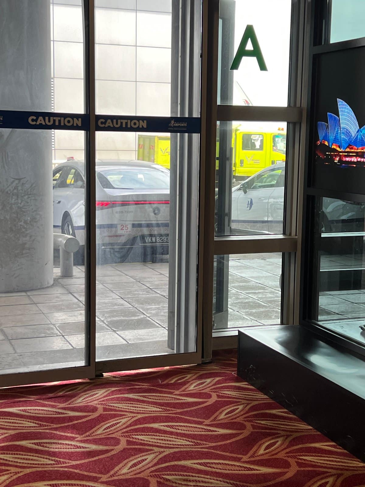 Glass revolving door marked with a large letter
