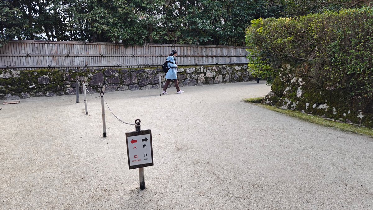 Gravel entry path with an information sign beside