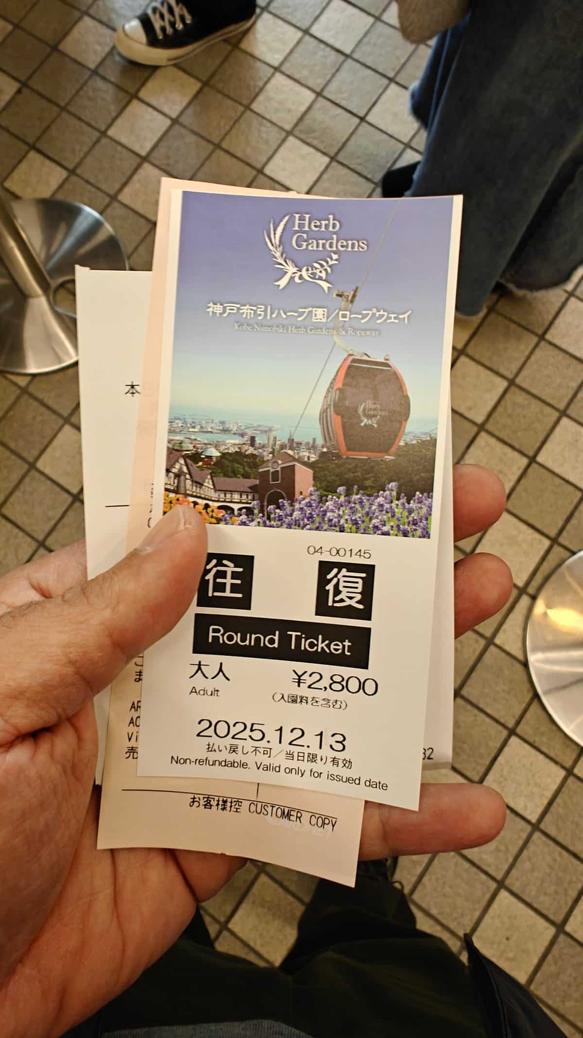 Hand holding the ropeway ticket - 往復 Round