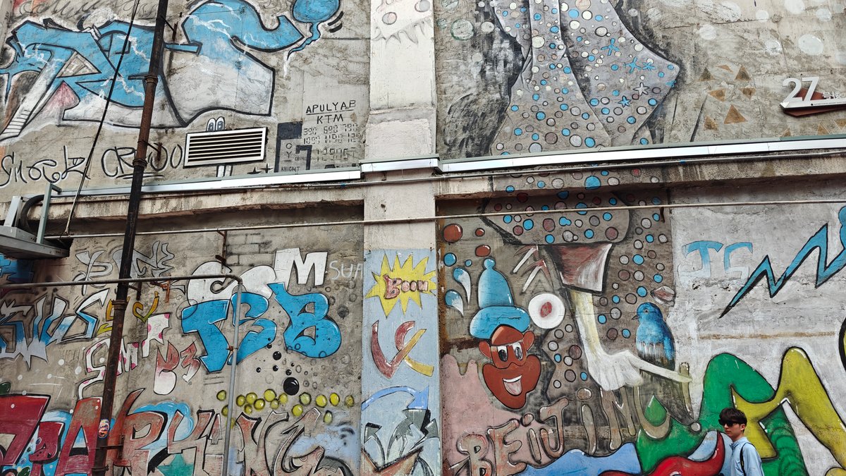 Horizontal stretch of the spray-painted graffiti wall along