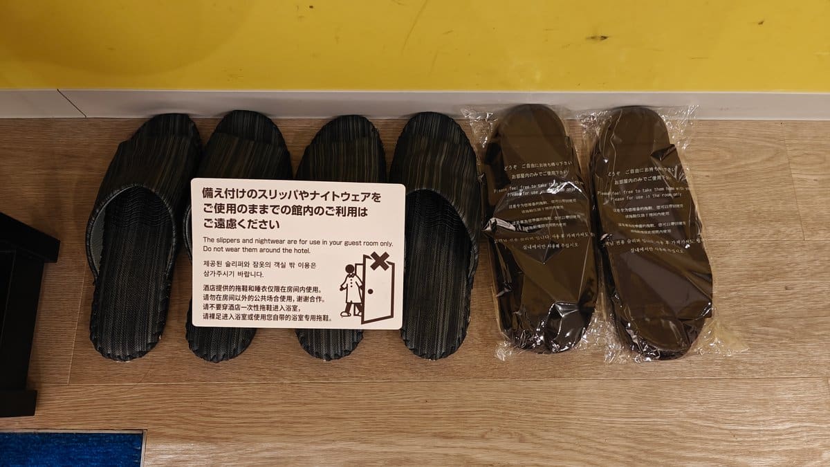 Hotel room slippers with usage instructions sign in