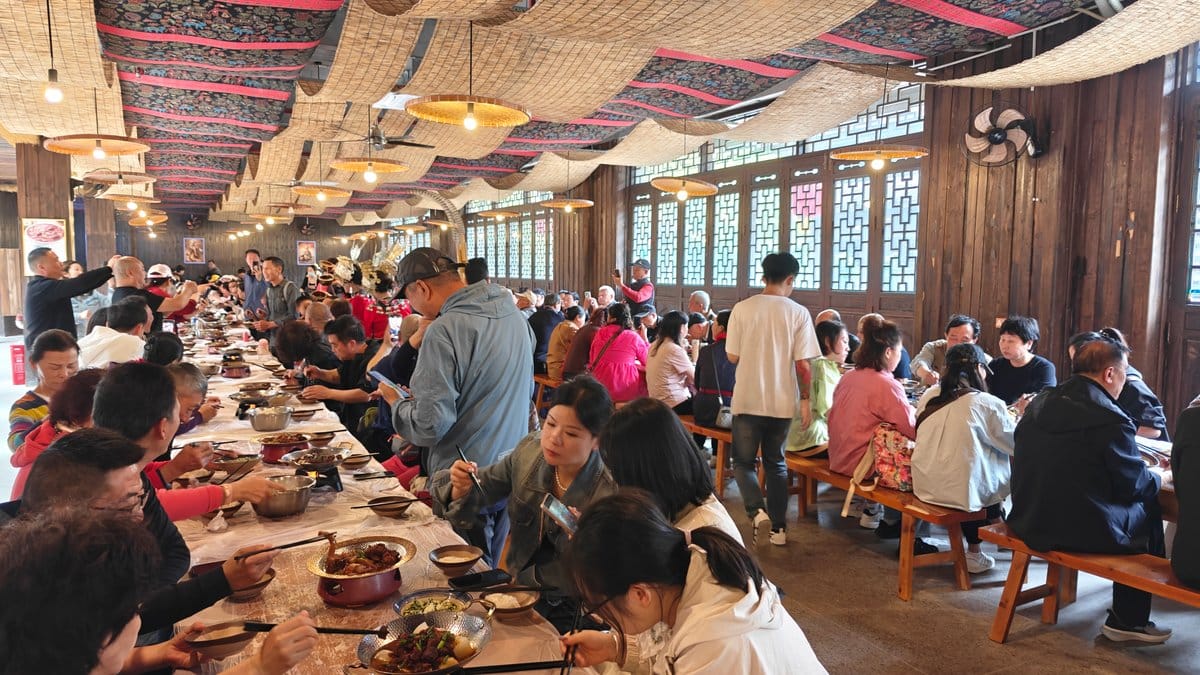 Interior: long communal banquet tables packed with diners