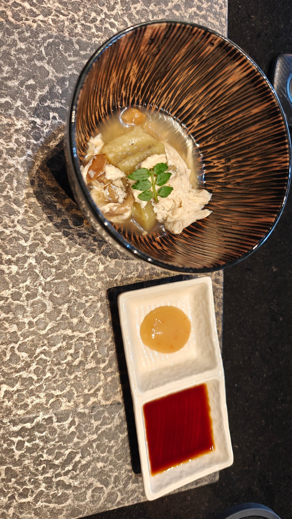 Live abalone on teppan grill with lemon slices,