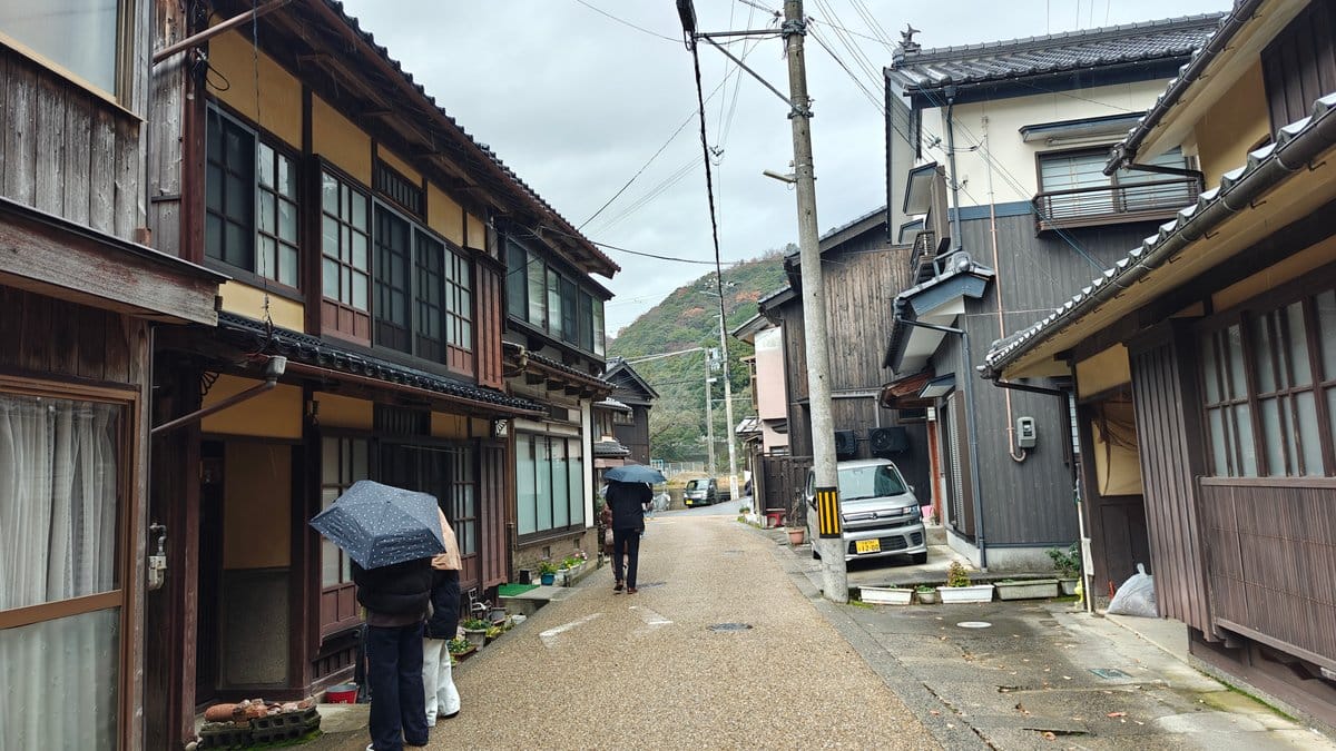 Narrow village street lined with traditional wooden houses