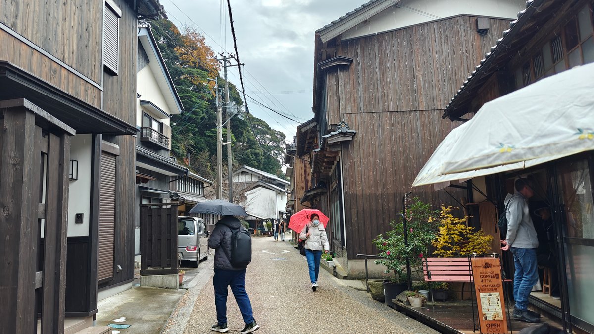 Old townhouse street in Ine with visitors under