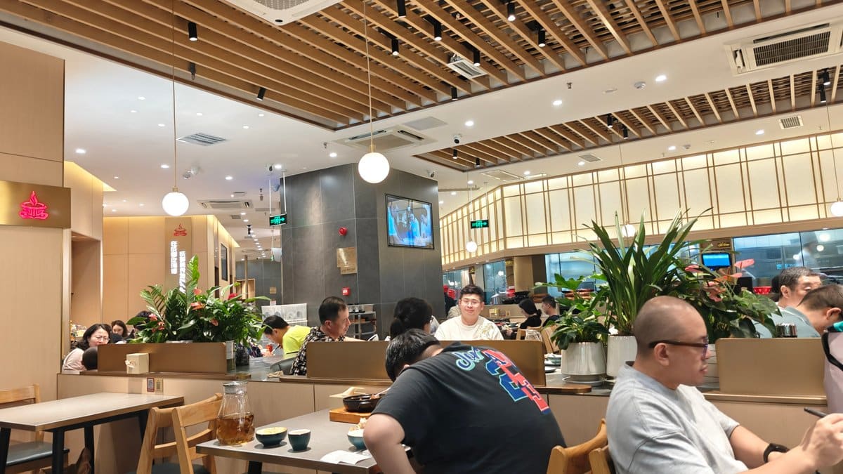 Restaurant interior — diners at wooden tables under