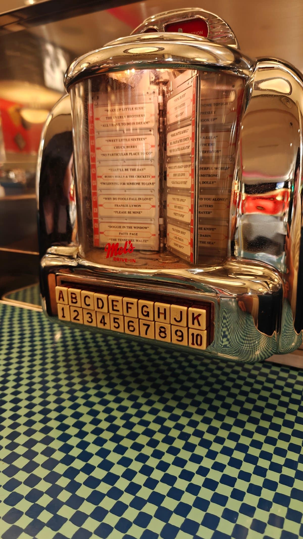 Retro tabletop jukebox selector on checkered table -