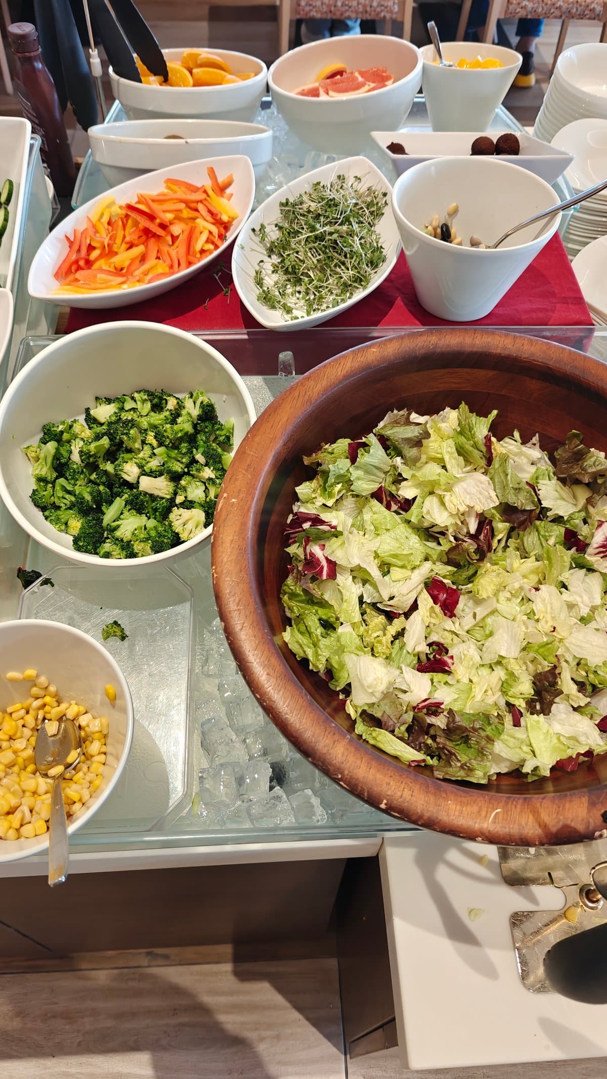 Salad bar with a large wooden bowl of