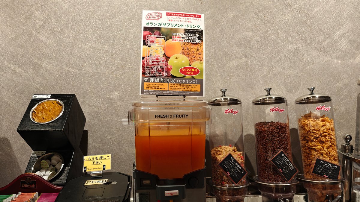 Self-serve orange juice dispenser with a fresh-juice poster