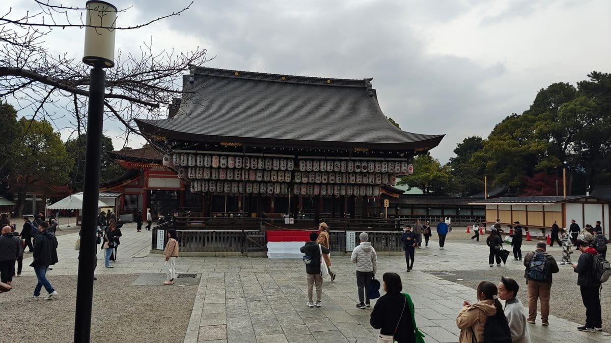 Shrine plaza with buildings, a lamppost and visitors