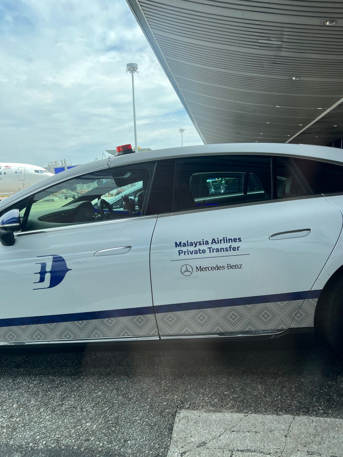 Side of the white Mercedes-Benz EQS transfer car