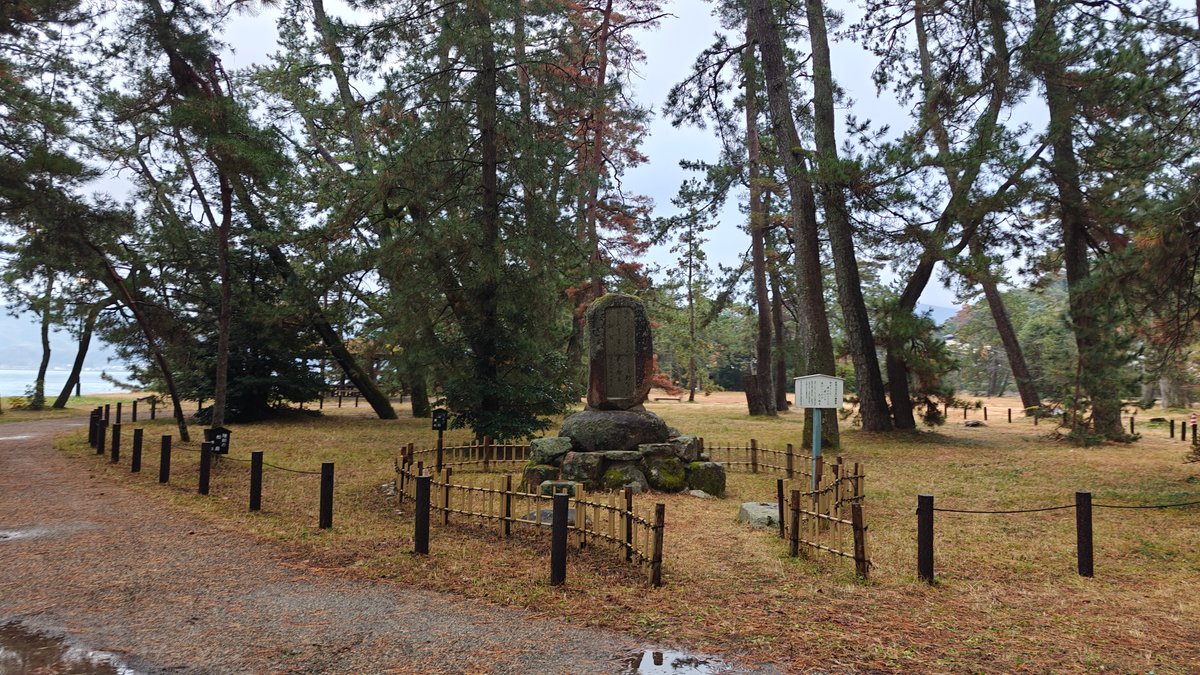 Stone stele in a fenced enclosure among the