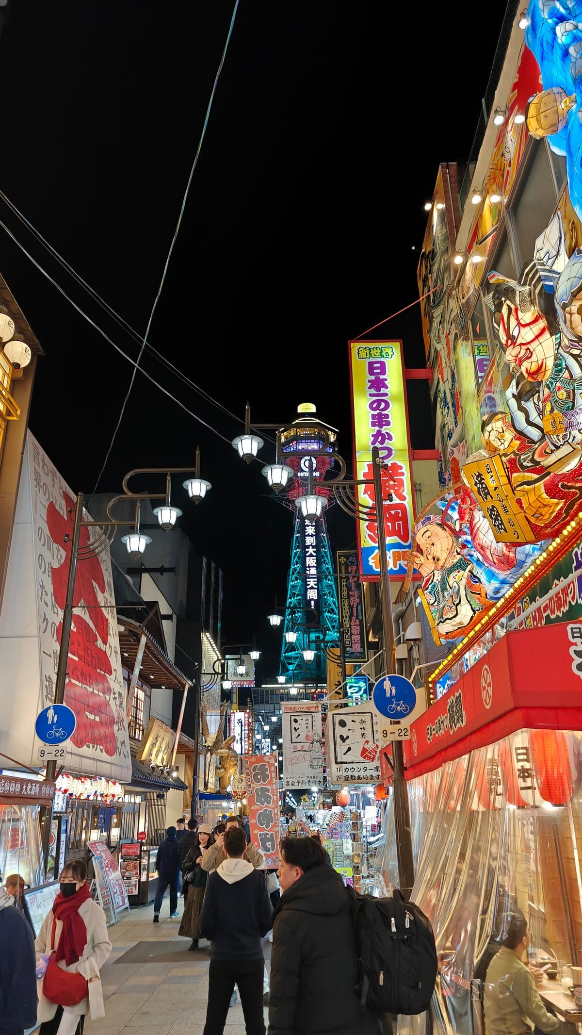Street view toward Tsutenkaku Tower with Yokozuna mural
