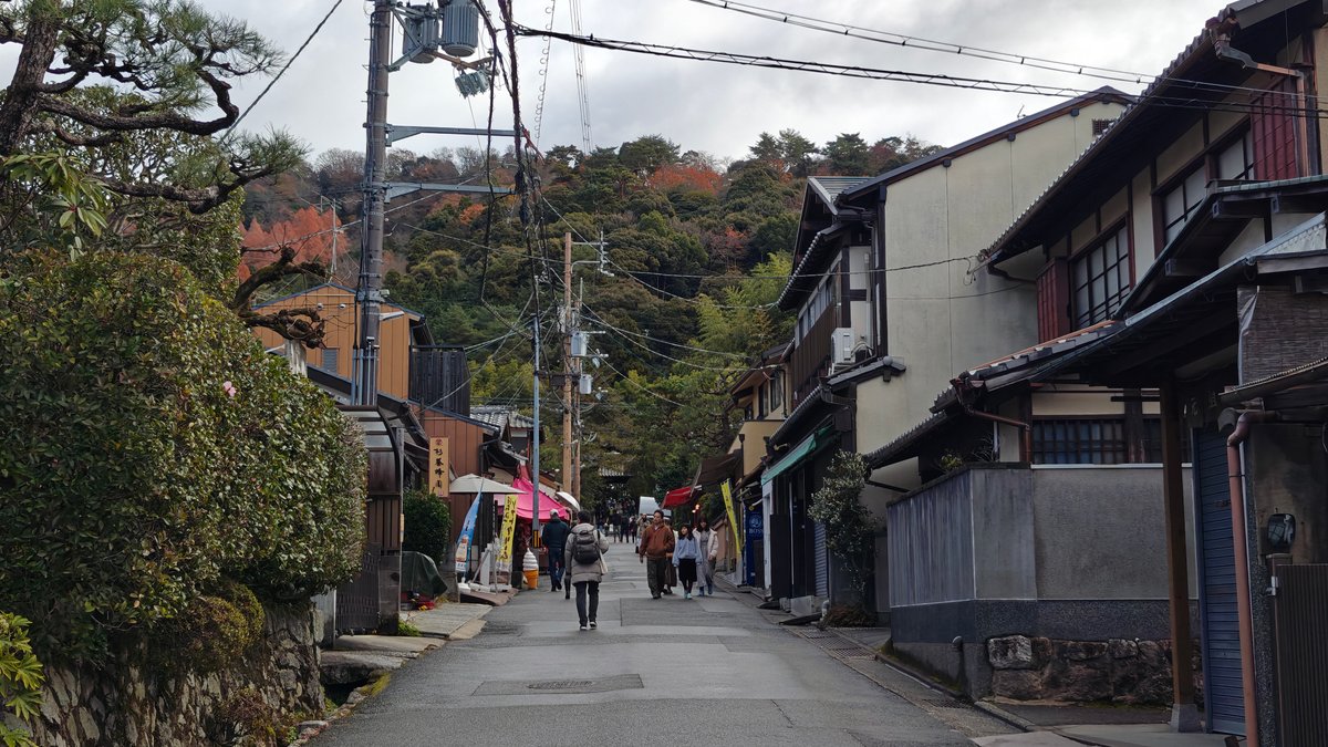 Traditional shop-lined approach street with visitors walking in