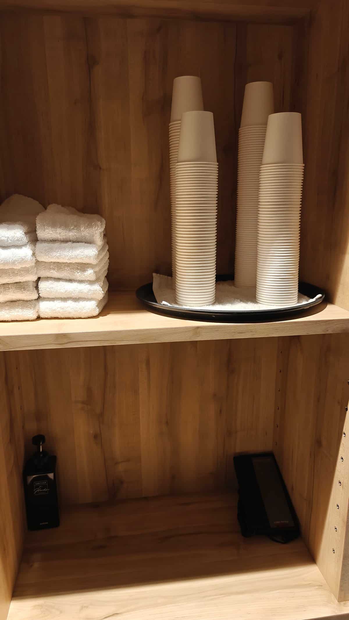 Water dispenser with cups and towel storage in